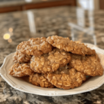 A plate piled high with soft, chewy vanishing oatmeal cookies, full of oats and raisins, shot as an amateur food photo.