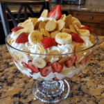 Homemade strawberry banana pudding layered with vanilla wafers, sliced bananas, and strawberries in a glass dish