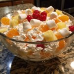 Ambrosia salad with mandarin oranges, pineapple, marshmallows, coconut, and cherries