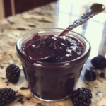 Homemade blackberry curd in a jar with spoon