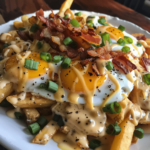 Breakfast poutine with crispy fries, fried eggs, and gravy topped with cheese and green onions