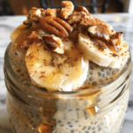 Creamy chai spiced chia pudding in a jar topped with banana slices, pecans, and chai spice