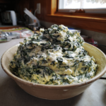 Creamed spinach with feta cheese in a ceramic bowl, thick and creamy with visible feta crumbles.