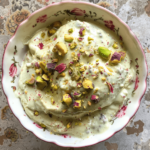Creamy rose pistachio ice cream in a bowl with chopped pistachios
