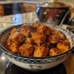 Crispy honey garlic tofu coated in sticky sauce in a bowl