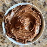 Eggless chocolate frosting in a bowl, smooth and fluffy