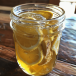 lemon ginger honey syrup in a glass jar with ginger slices