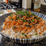 Spicy salmon sushi bake layered with rice, salmon, spicy mayo and furikake in a baking dish