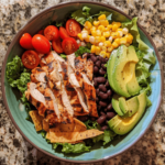 Spicy Southwest Salad with grilled chicken, black beans, corn, avocado, and tortilla strips in a bowl