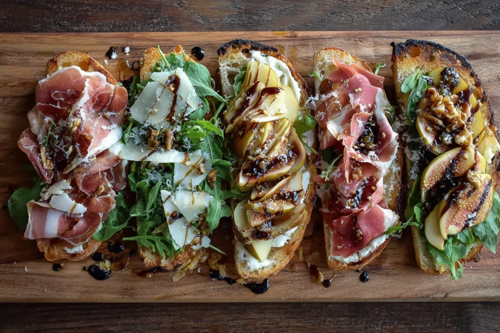 Prosciutto sandwich ingredients flat lay with bread, prosciutto, cheese, arugula, pear, fig jam, honey, olive oil, and balsamic
