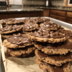 Dandy-Do Cookies stacked on a tray with chocolate peanut butter coating