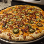 Jalapeño popper pizza with cream cheese, melty cheese, jalapeños, and bacon on a crispy crust