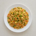 Egg Fried Rice on a white plate with visible egg pieces and vegetables