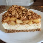 Slice of Apple Crisp Cheesecake showing the layered filling and crumble