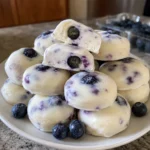 A plate of 3-Ingredient Blueberry Greek Yogurt Bites with one bite cut in half