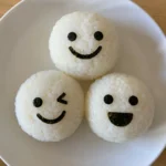 Close-up of emoji rice balls with nori faces