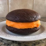 Single Halloween Whoopie Pie with orange buttercream filling