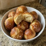 Bowl of Homemade Soft Pretzel Bites with one bite torn open