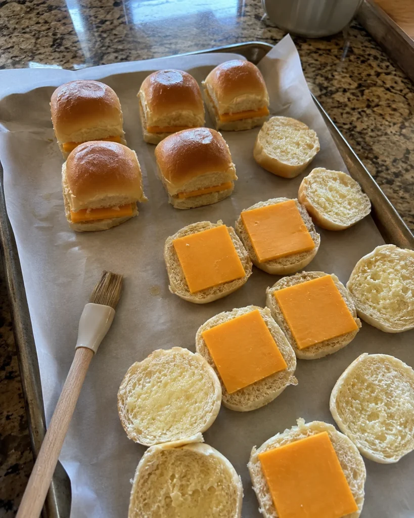 Assembling mini grilled cheese for school on a baking sheet before baking