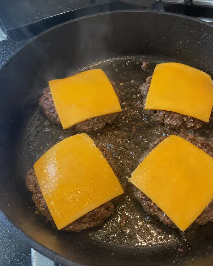 Cooking spiced beef patties for Pumpkin Sliders Recipe for Halloween