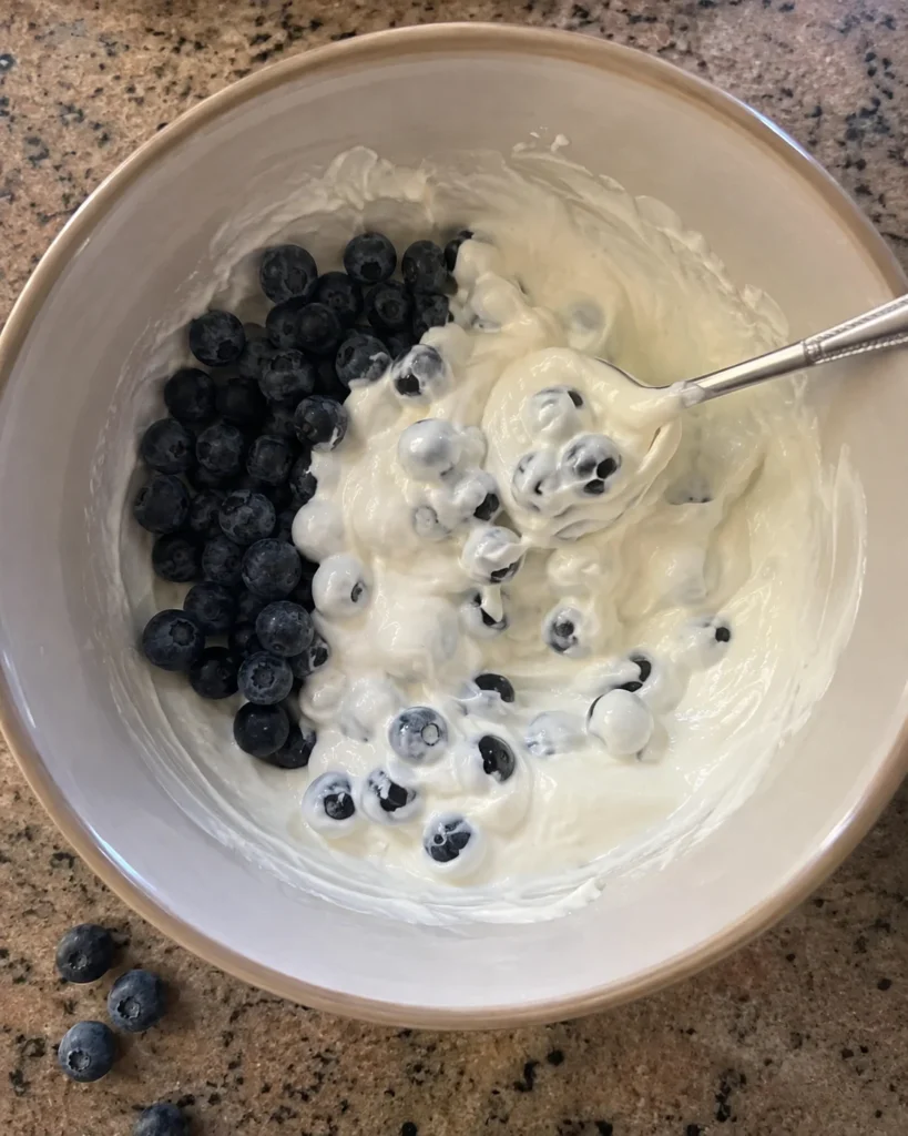 Folding blueberries into yogurt for 3-Ingredient Blueberry Greek Yogurt Bites