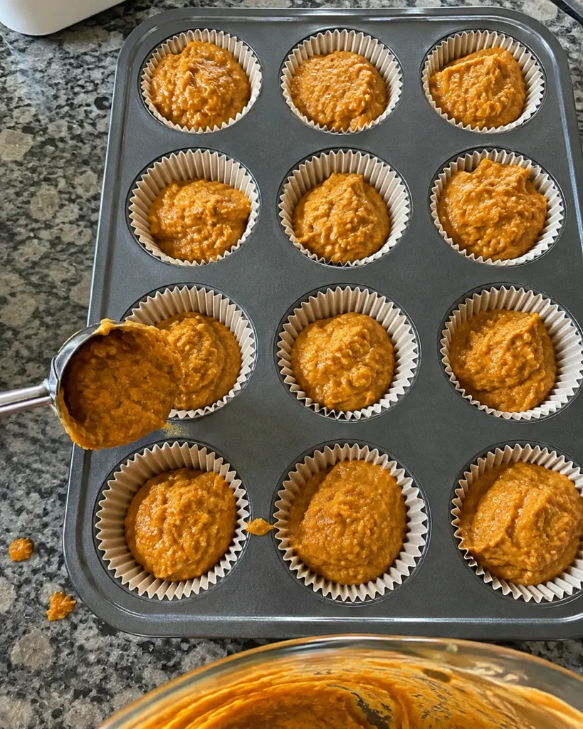 Low Carb Keto Pumpkin Muffins batter being scooped into a muffin tin