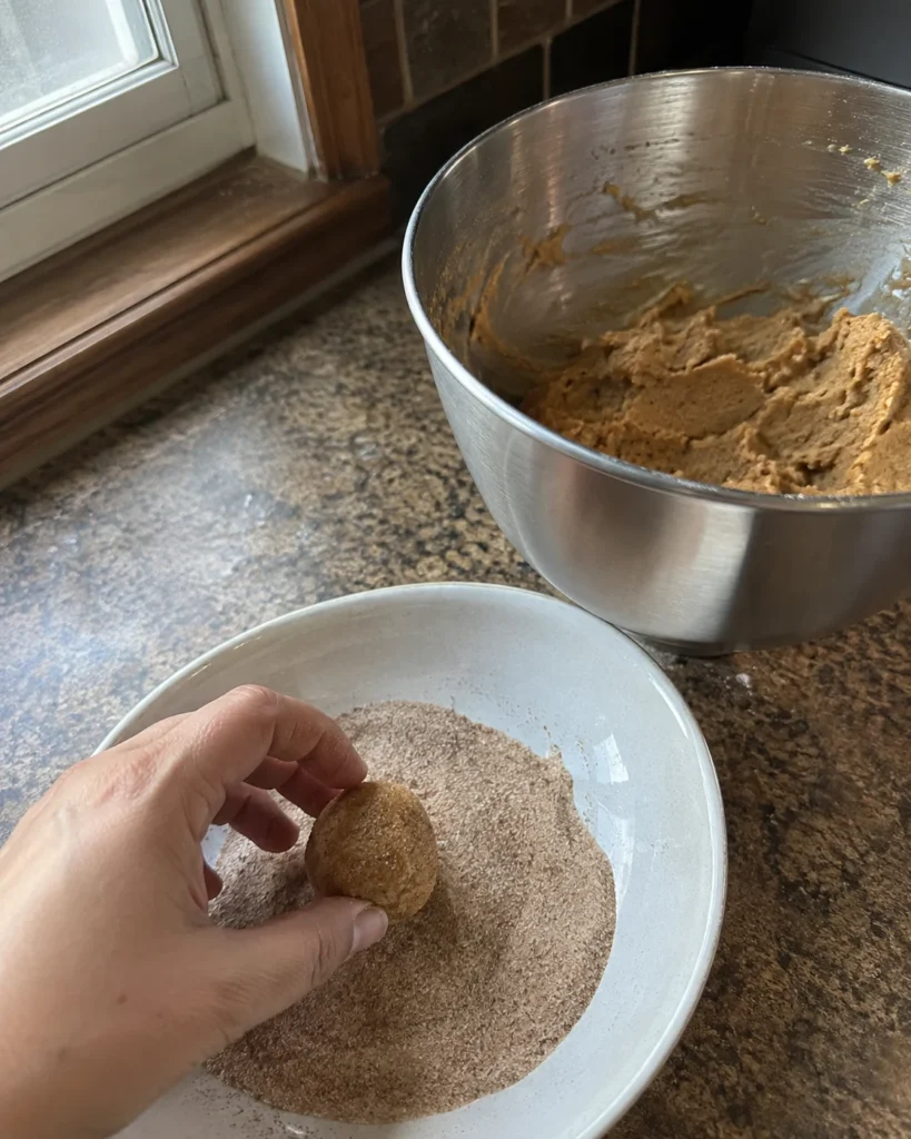Rolling Apple Butter Cookies dough in cinnamon sugar