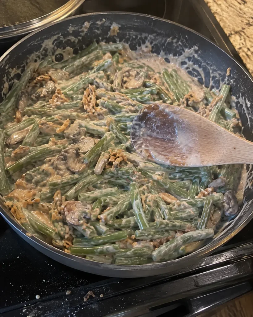 Stirring creamy sauce into green beans for Green Bean Casserole