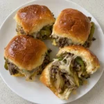 Close view of Philly cheesesteak slider buns showing the ribeye and melted cheese filling